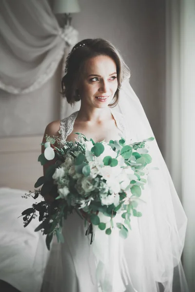 Linda noiva em roupão posando e se preparando para o rosto cerimônia de casamento em uma sala — Fotografia de Stock