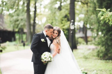 Yeni evli çift el ele tutuşurken parkta koşup zıplıyorlar.