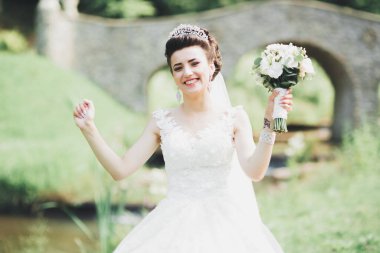 Parkta poz veren gelinlikli güzel, lüks bir gelin.