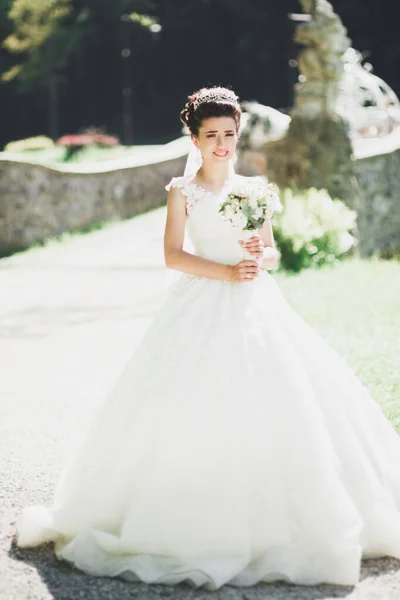 Retrato de novia impresionante con el pelo largo posando con gran ramo — Foto de Stock