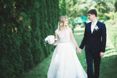 Gelin ve damat el ele tutuşuyor.