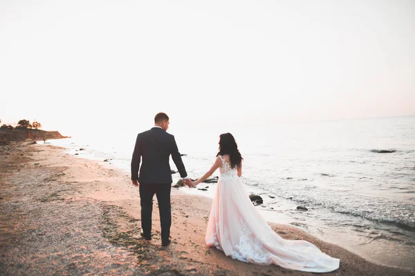 Boda pareja, novio, novia con ramo posando cerca del mar y el cielo azul —  Fotos de Stock