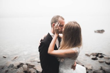 Mükemmel bir çift gelin ve damat düğün günlerinde poz verip öpüşürler.