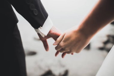 Gelin ve damat el ele tutuşuyor.