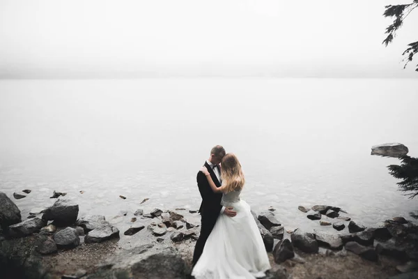 Gelukkig en romantisch tafereel van net getrouwd jong bruidspaar poserend op mooi strand — Stockfoto