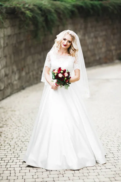 Hermosa novia joven de lujo en vestido de novia posando en el parque —  Fotos de Stock