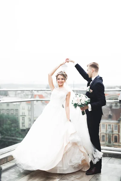 Schöne Braut dreht mit perfektem Kleid auf dem Balkon — Stockfoto