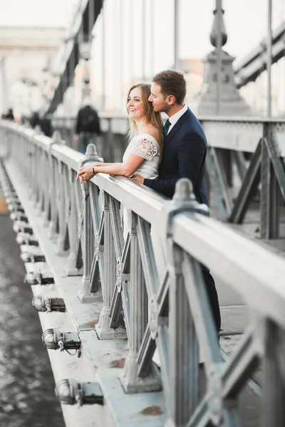 Fiatal, gyönyörű, stílusos pár friss házasok a hídon — Stock Fotó