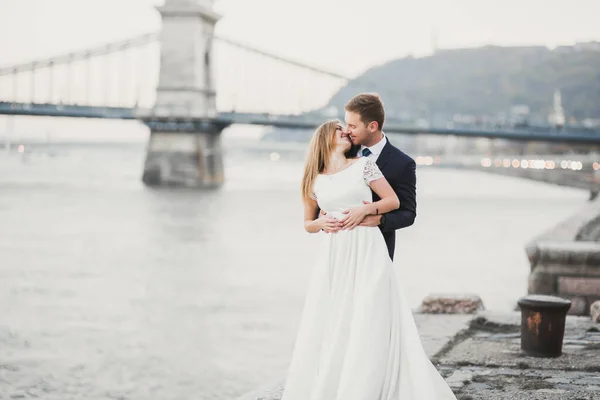 Elegant elegant glad blond brud och vacker brudgum på bakgrunden av en vacker flod. — Stockfoto