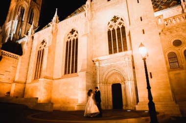 Harika bir tarihi binanın yakınında mükemmel bir elbiseyle dönen güzel bir gelin.