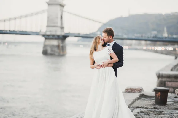 Elegant stylish happy blonde bride and gorgeous groom on the background of a beautiful river. — Stock Photo, Image