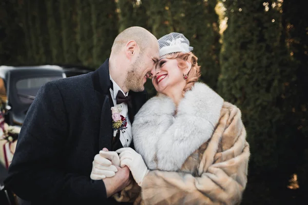 Romantic, fairytale, happy newlywed couple hugging and kissing in a park, trees in background — Stock Photo, Image