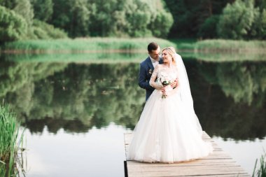 Romantik düğün anı, yeni evli çiftin gülümseyen portresi, gelin ve damadın kucaklaşması