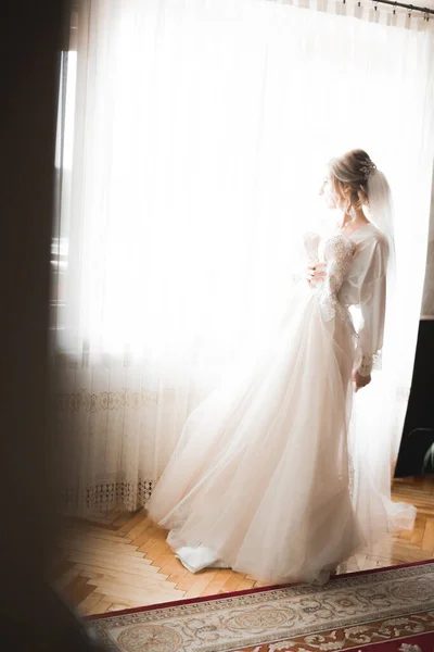 Noiva de luxo em vestido branco posando enquanto se prepara para a cerimônia de casamento — Fotografia de Stock