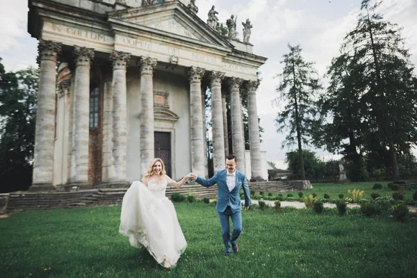 Frisch verheiratetes Paar rennt und springt im Park und hält Händchen — Stockfoto