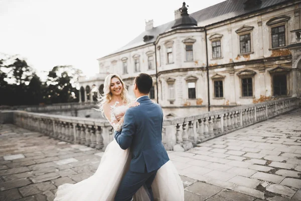 Schöne Braut und Bräutigam umarmen und küssen sich am Hochzeitstag im Freien — Stockfoto