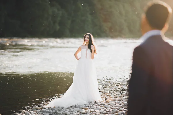 秀丽时尚的金发碧眼的新娘和美丽的新郎在高山上美丽的河流的背景下 — 图库照片