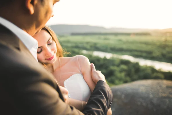 Bröllopspar på naturen kramar varandra. Vacker modell flicka i vit klänning. Man i kostym — Stockfoto