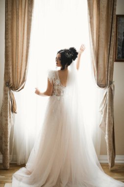 Gelin çiçekli büyük ve güzel bir düğün buketi tutuyor.