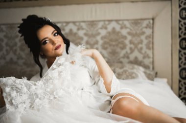 Cüppeli muhteşem gelin bir odada düğün töreni için poz veriyor ve hazırlanıyor.