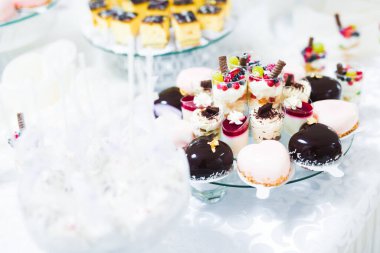 Lezzetli ve tatlı bir tatlı masası. Kapalı resepsiyonda küçük kekler ve shot 'lar var.