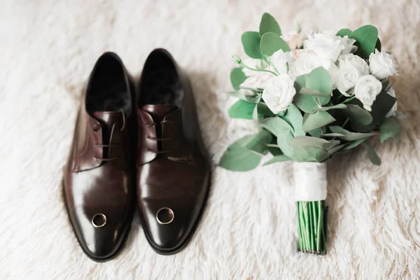 Herrenmodeschuhe mit zwei goldenen Eheringen und wunderschönem Brautstrauß mit verschiedenen Blumen, Rosen — Stockfoto