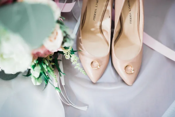 Beautiful toned picture with wedding rings and wedding shoes — Stock Photo, Image
