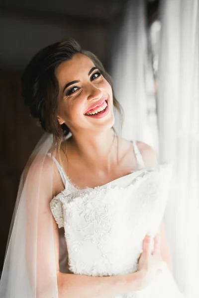 Linda noiva em roupão posando e se preparando para o rosto cerimônia de casamento em uma sala — Fotografia de Stock