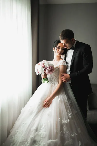 Bröllopspar på naturen kramar varandra. Vacker modell flicka i vit klänning. Man i kostym — Stockfoto