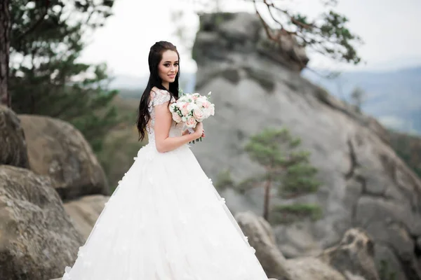 Ritratto di splendida sposa con capelli lunghi in posa con grande bouquet — Foto Stock