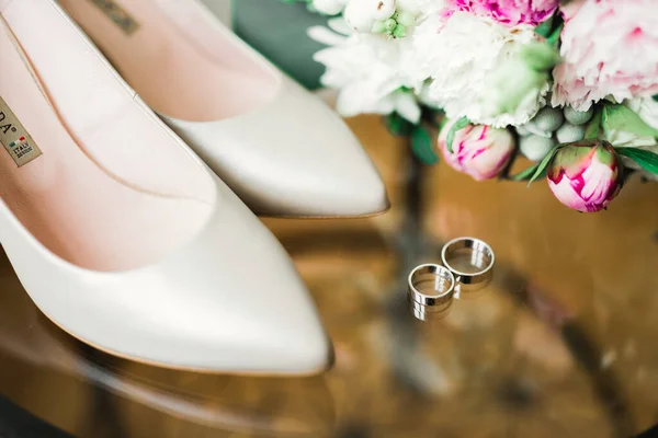 Mooie getinte foto met trouwringen en bruidsschoenen — Stockfoto