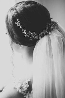 Cüppeli muhteşem gelin bir odada düğün töreni için poz veriyor ve hazırlanıyor.