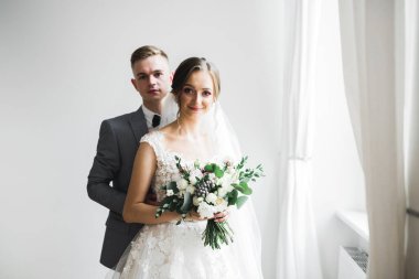 Doğadaki düğün çifti birbirine sarılıyor. Beyaz elbiseli güzel bir kız. Takım elbiseli adam