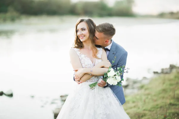 Boda pareja, novio y novia abrazos, al aire libre cerca del río —  Fotos de Stock