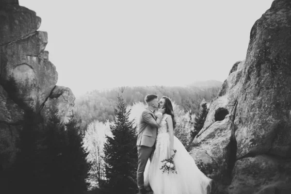 Bela noiva e noivo abraçando e beijando em seu dia de casamento ao ar livre — Fotografia de Stock