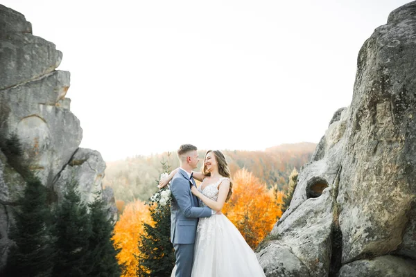 Beautiful bride with a bouquet on mountain background at sunset — Stock Photo, Image