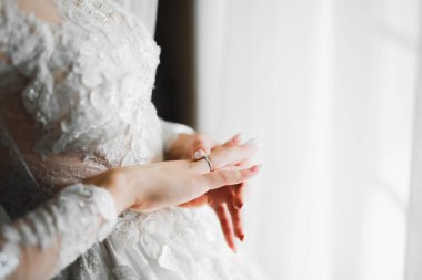 Beyaz elbiseli lüks gelin düğün törenine hazırlanırken poz veriyor.