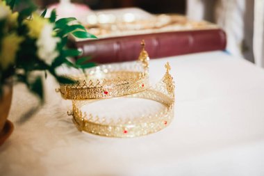 Kilisedeki masanın üzerinde altın taçlar var.