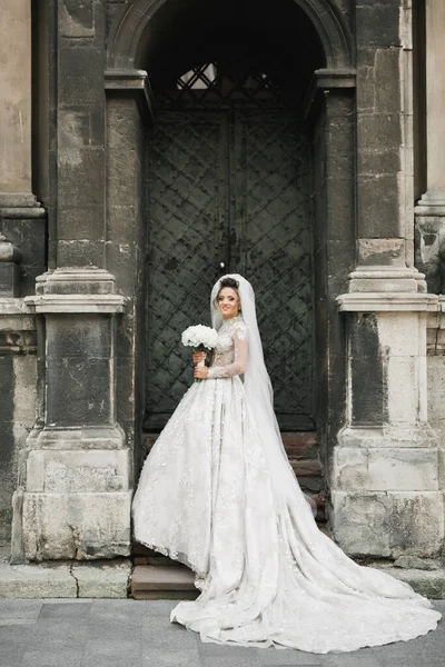 Gelin çiçekli büyük ve güzel bir düğün buketi tutuyor.