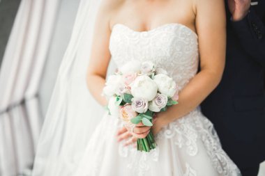 Çiçek buketi taşıyan mükemmel bir düğün çifti.