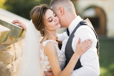 Romantik düğün anı, yeni evli çiftin gülümseyen portresi, gelin ve damadın kucaklaşması