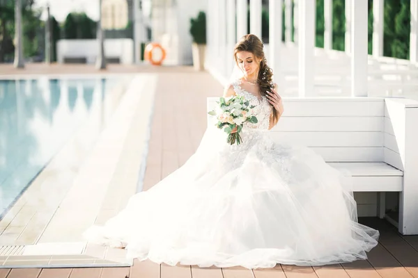 Retrato de novia impresionante con el pelo largo posando con gran ramo — Foto de Stock