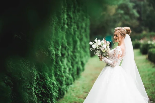 Retrato de belleza de la novia con vestido de novia de moda con plumas con maquillaje y peinado de lujo deleite — Foto de Stock