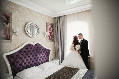 Göz kamaştırıcı mutlu çift birbirine yakın duruyor ve gözlerinin içine bakıyor.