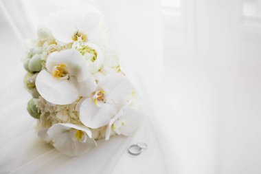 Çiçek buketinin arka planında alyanslar olan güzel renkli bir resim.