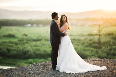 Romantik düğün anı, yeni evli çiftin gülümseyen portresi, gelin ve damadın kucaklaşması