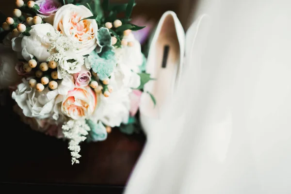 Brides wedding shoes with a bouquet with roses and other flowers — 图库照片