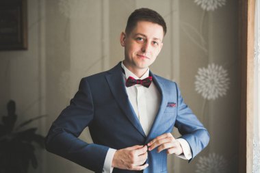 Güzel adam, damat poz veriyor ve düğüne hazırlanıyor.