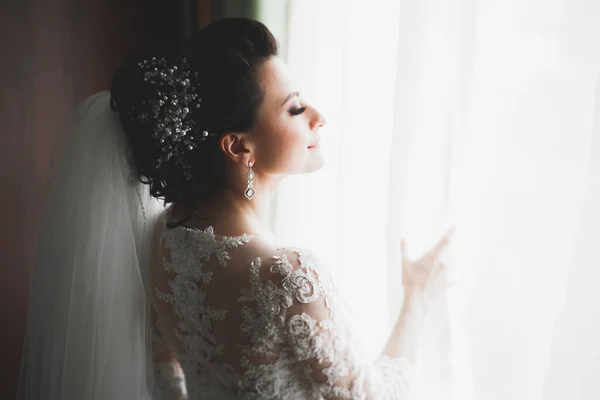 Novia de lujo en vestido blanco posando mientras se prepara para la ceremonia de boda — Foto de Stock