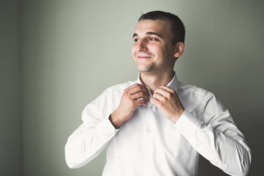 Güzel adam, damat poz veriyor ve düğüne hazırlanıyor.